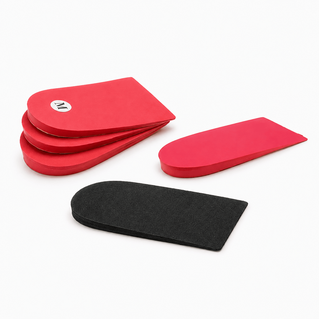 Three red and one black curved foam heel lifts arranged on a clean white background. One redheel lift has a small circular white logo with black lettering.
