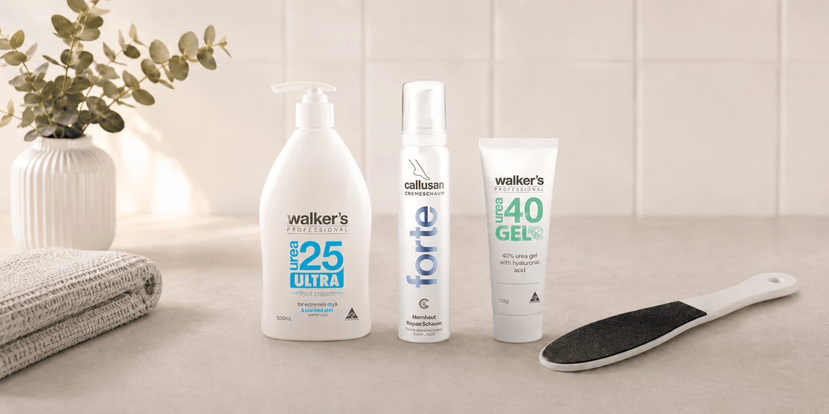 Four Walker's footcare products arranged on a light countertop: a white pump bottle labeled walkers urea 25 Ultra, callusan forte foot foam,  a tube of walkers urea 40 Gel, and a black-and-white foot file for our foot cream collection at the footcare shop